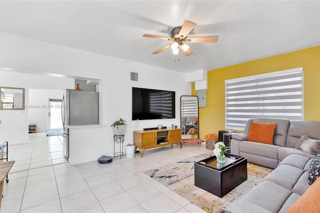 tiled living room featuring ceiling fan and plenty of natural light