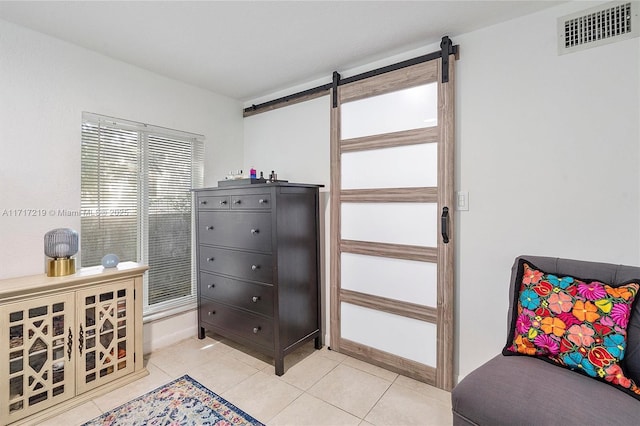 interior space featuring light tile patterned floors and a barn door