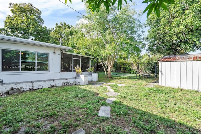 view of yard featuring a shed and a sunroom