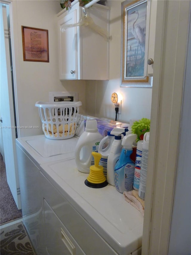 laundry area with washing machine and dryer and cabinets