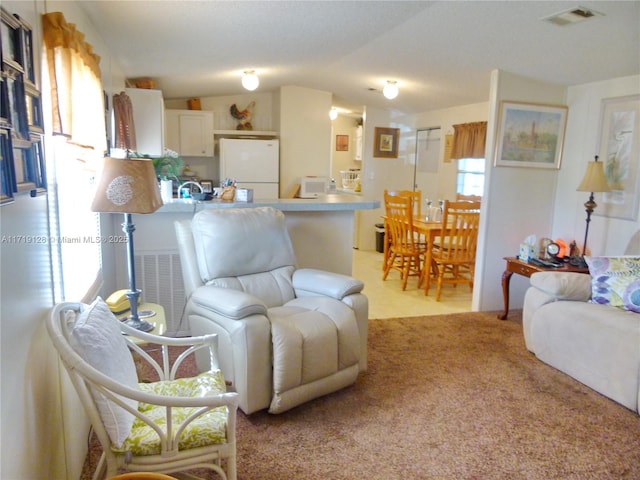 living room with light colored carpet and vaulted ceiling