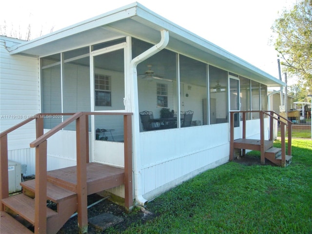 view of side of home featuring a lawn and a sunroom