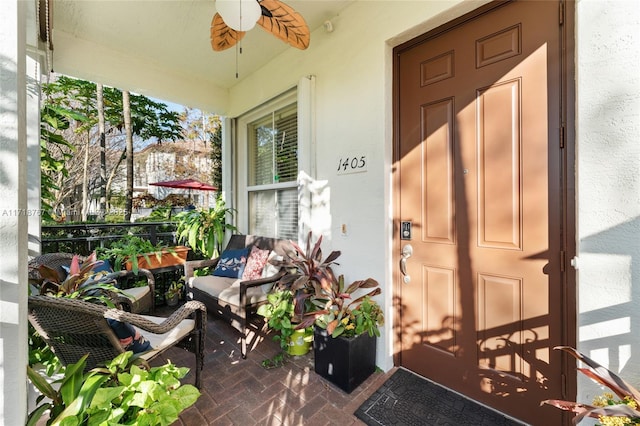 entrance to property with ceiling fan and covered porch