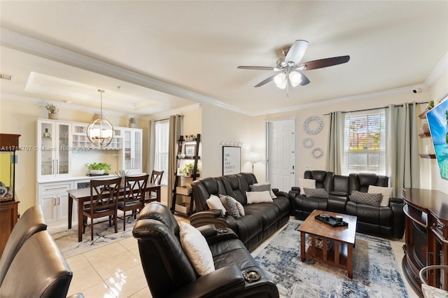 tiled living room featuring a tray ceiling, crown molding, and ceiling fan with notable chandelier