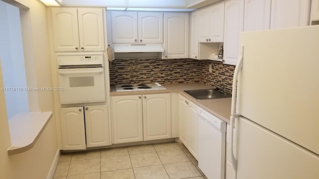 kitchen with white appliances, tasteful backsplash, white cabinetry, and sink