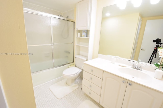 full bathroom featuring tile patterned flooring, vanity, toilet, and combined bath / shower with glass door