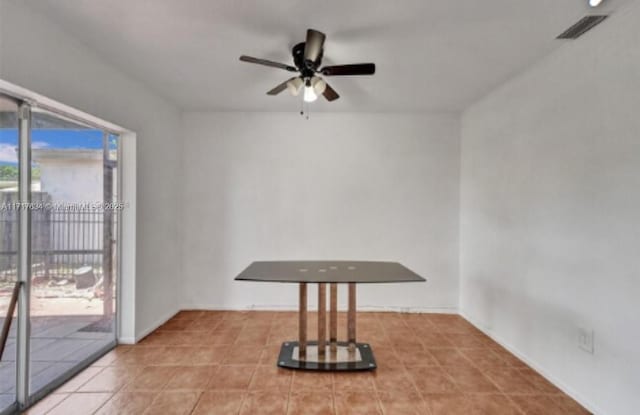 unfurnished dining area with tile patterned flooring and ceiling fan