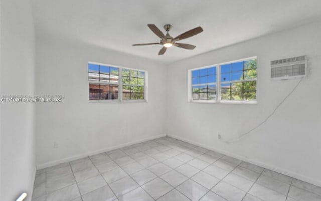 spare room with an AC wall unit and ceiling fan