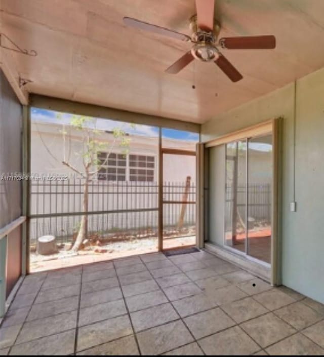 unfurnished sunroom with ceiling fan