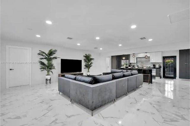 living room featuring marble finish floor, visible vents, and recessed lighting