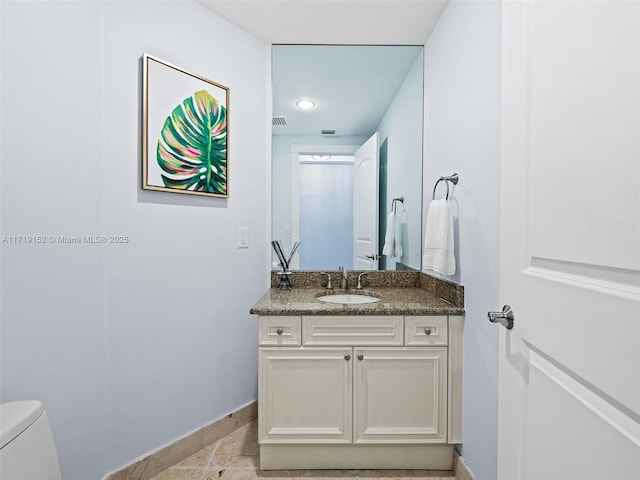 bathroom featuring vanity and toilet