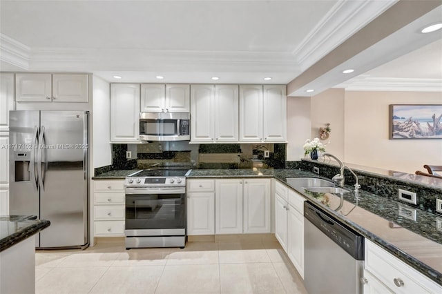 kitchen featuring a sink, dark stone counters, appliances with stainless steel finishes, and ornamental molding