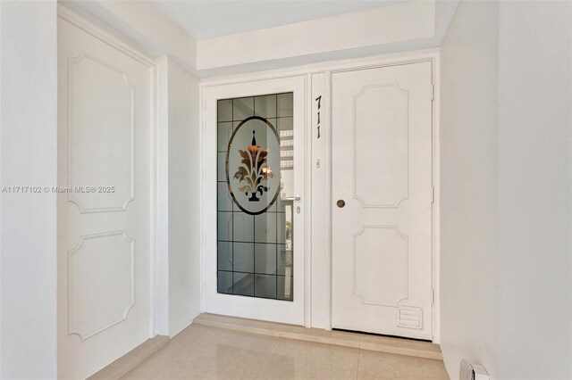 tiled entryway with a baseboard heating unit