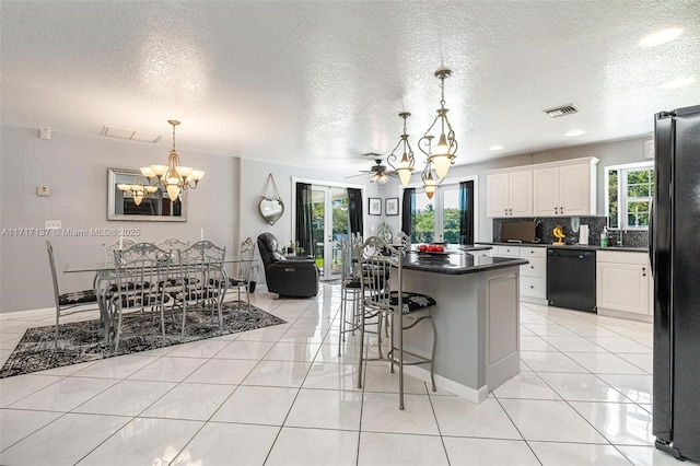 kitchen featuring backsplash, ceiling fan with notable chandelier, black appliances, decorative light fixtures, and white cabinetry