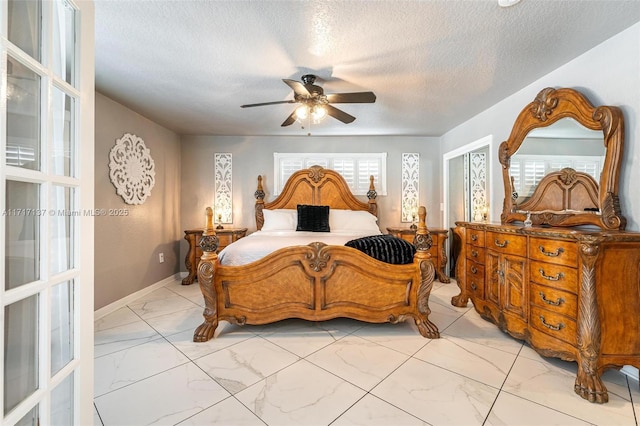 bedroom with ceiling fan and a textured ceiling