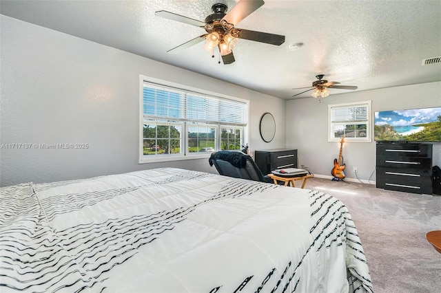 bedroom featuring ceiling fan, light colored carpet, and a textured ceiling