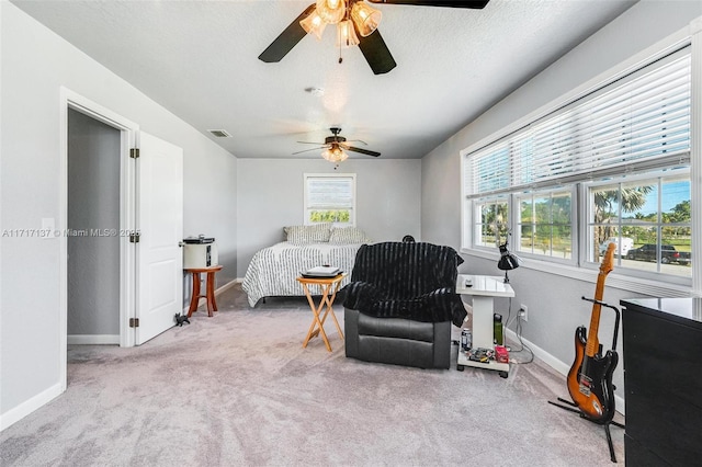 bedroom with a textured ceiling, ceiling fan, and light carpet