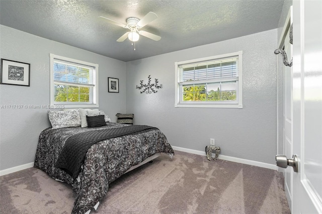 carpeted bedroom with ceiling fan and a textured ceiling