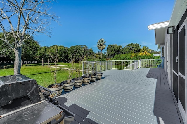 wooden deck with area for grilling and a yard