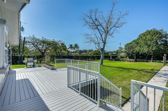 wooden deck with a lawn and a grill