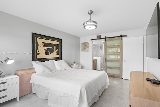 bedroom with ensuite bathroom and a barn door