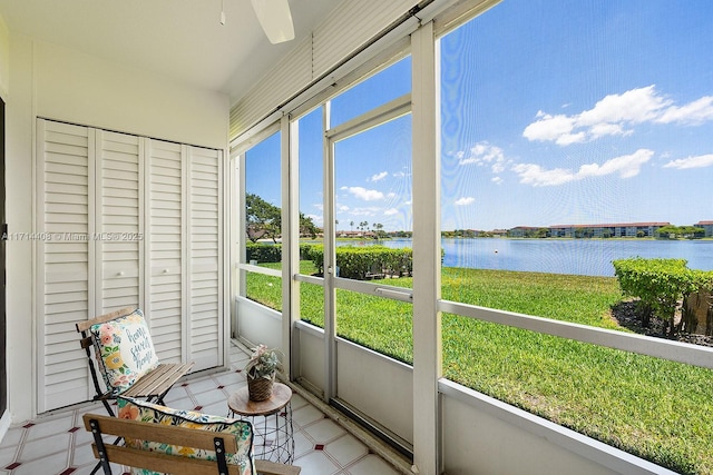 sunroom featuring a water view and ceiling fan