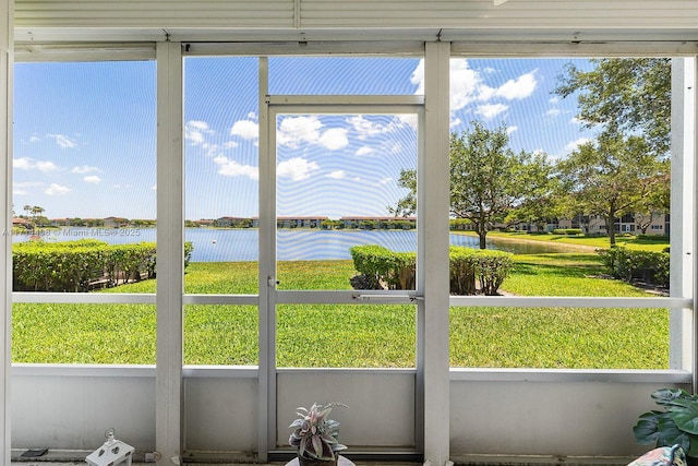 sunroom / solarium featuring a water view