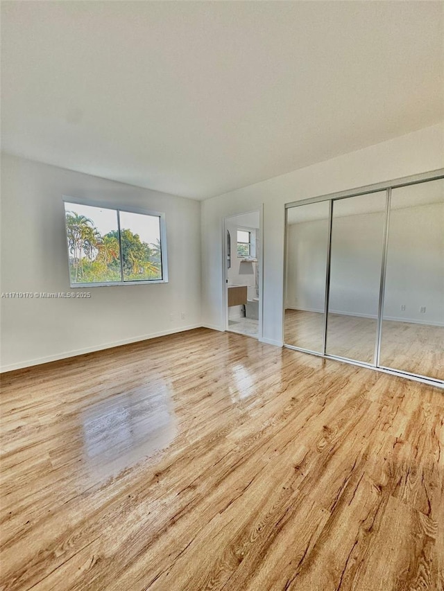 unfurnished bedroom featuring light wood-type flooring and a closet