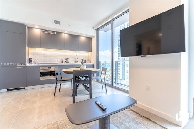 dining space with expansive windows and light tile patterned flooring