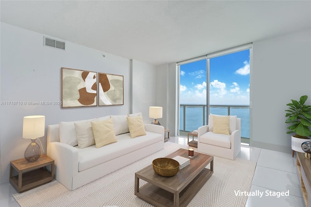 tiled living room with expansive windows and a water view