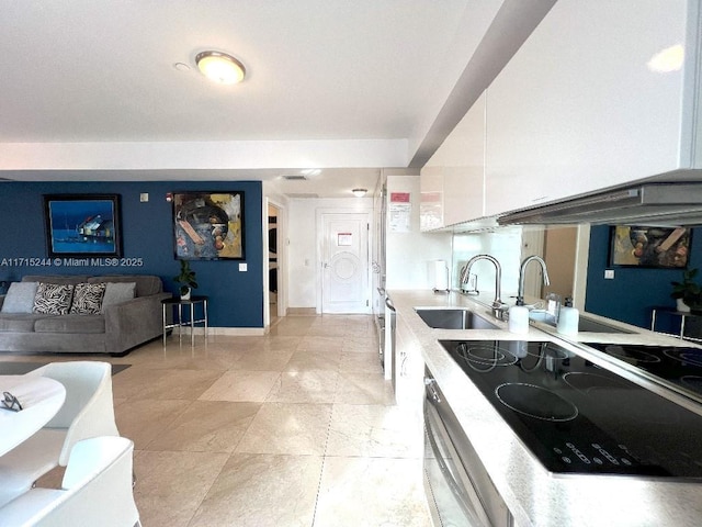 kitchen with black electric stovetop, wall oven, white cabinetry, and sink