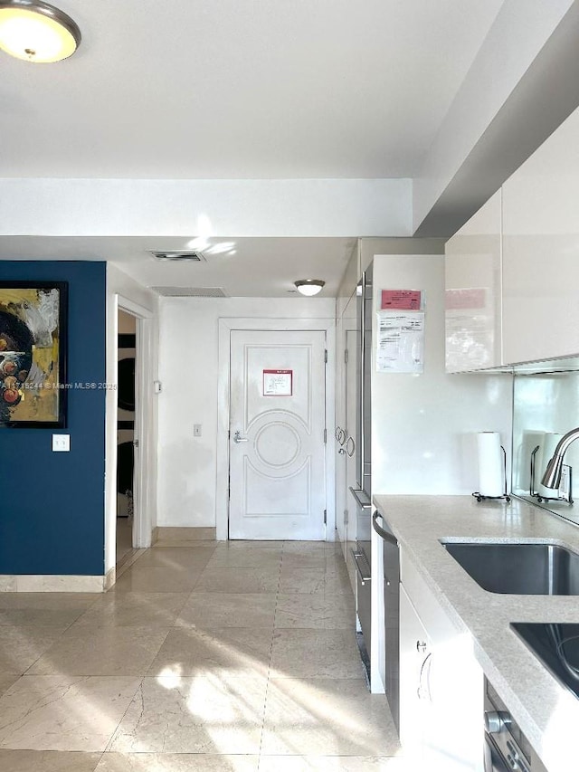 kitchen with black electric cooktop, sink, and white cabinets