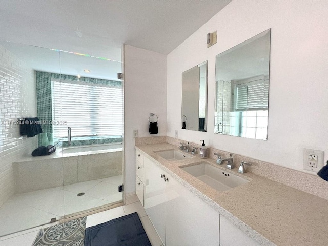 bathroom with tile patterned floors, a wealth of natural light, vanity, and independent shower and bath