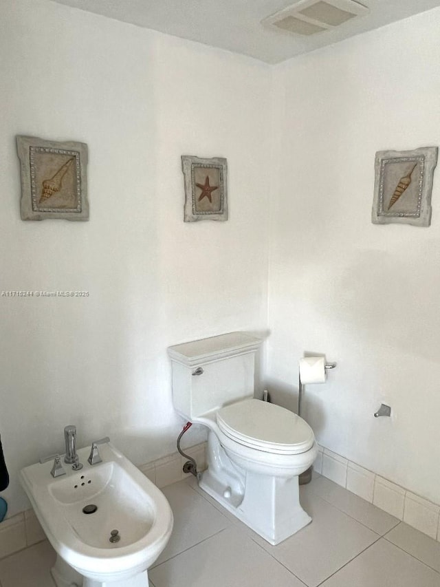 bathroom with tile patterned floors, toilet, and a bidet