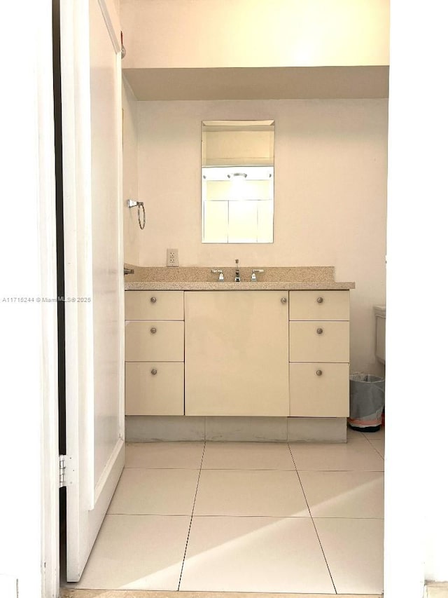 bathroom with tile patterned flooring, vanity, and toilet