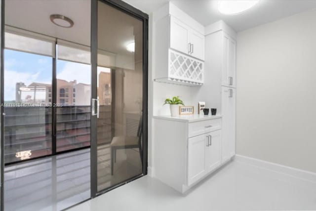 bar featuring white cabinets and expansive windows