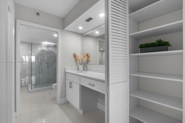 bathroom with vanity, a shower with shower door, and toilet