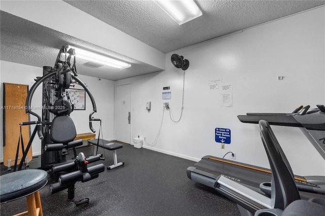 workout room featuring a textured ceiling