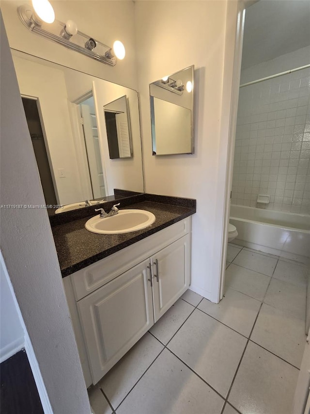 full bathroom featuring tile patterned flooring, vanity, toilet, and tiled shower / bath combo