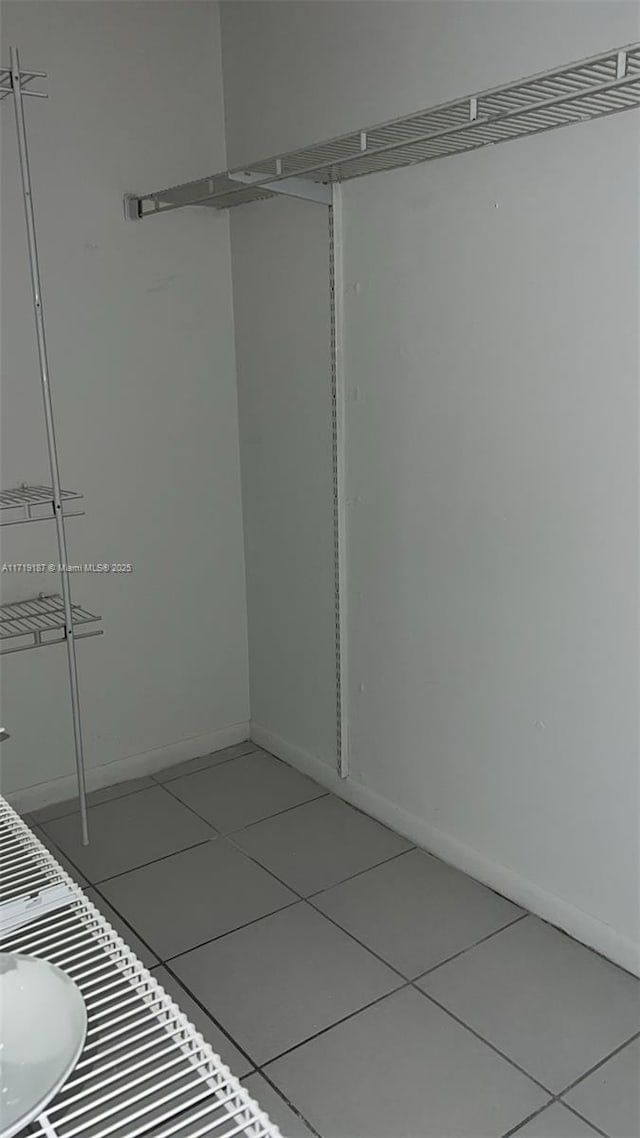 walk in closet with tile patterned floors