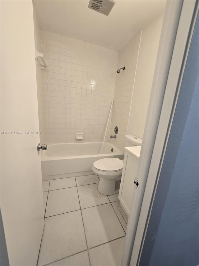 full bathroom featuring tile patterned floors, tiled shower / bath, vanity, and toilet