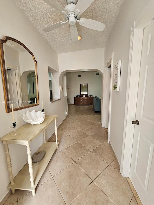 hallway featuring light tile patterned flooring and a textured ceiling