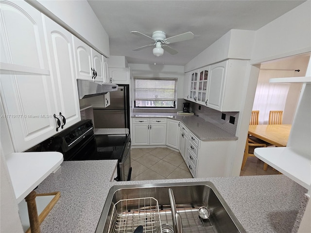 kitchen featuring stainless steel fridge, white cabinetry, electric range, and light tile patterned floors