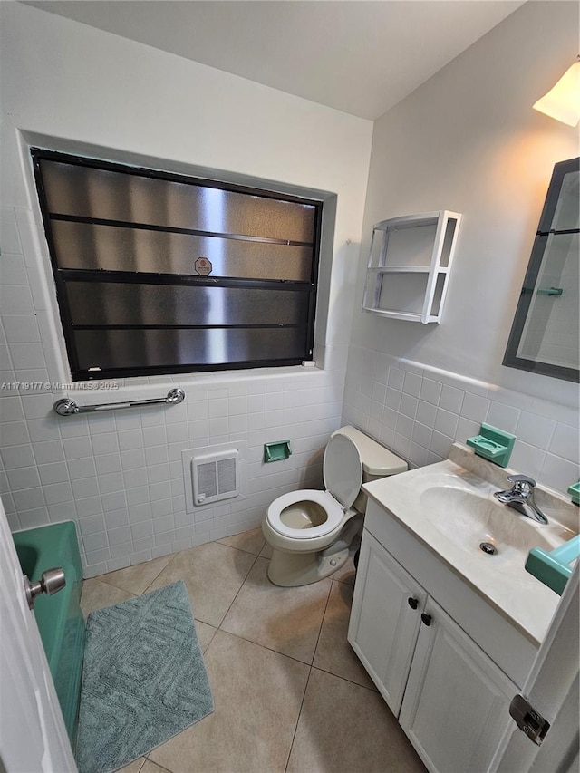 bathroom featuring tile patterned floors, vanity, toilet, and tile walls