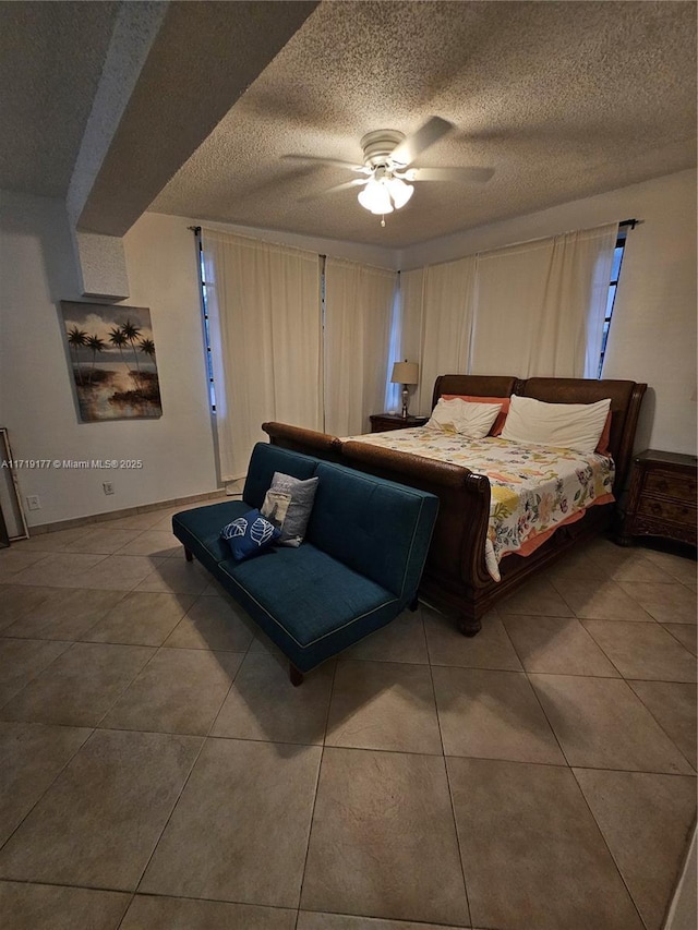 tiled bedroom with ceiling fan and a textured ceiling