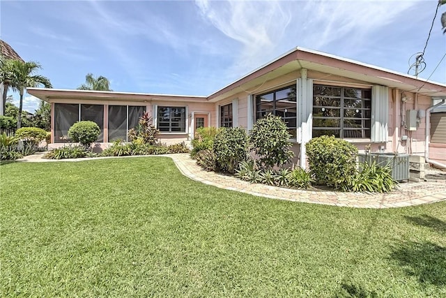 back of house with a sunroom, a yard, and cooling unit