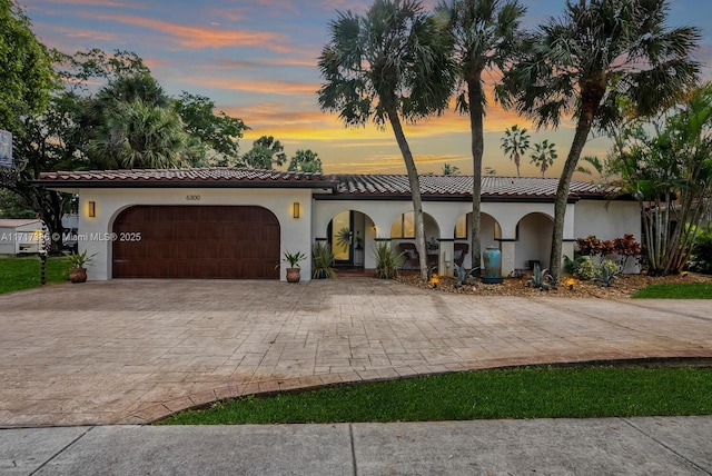 mediterranean / spanish home featuring a garage