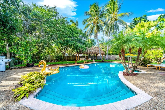 pool at dusk with a patio area