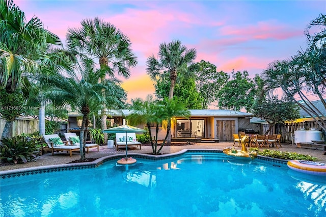 view of swimming pool with a fenced in pool, fence, an outdoor structure, and a patio