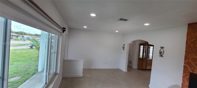 spare room with baseboards, visible vents, arched walkways, and recessed lighting